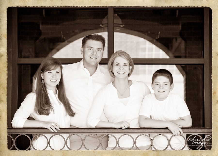 family portrait in front of arched window